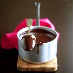 Tablespoon lying on pan of melted couverture