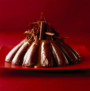 Chocolate dessert with grated chocolate on red plate