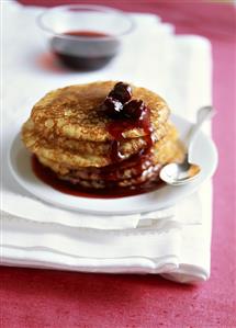 A pile of blinis with cherry compote