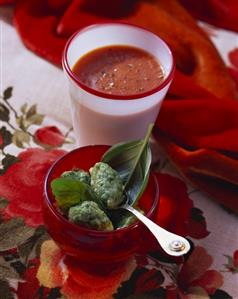 Tomato soup in glass and basil dumplings in bowl