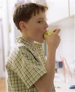 Boy biting into an apple