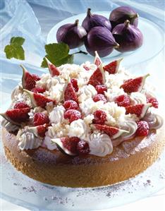 Raspberry and fig cake with cream and whole figs behind it