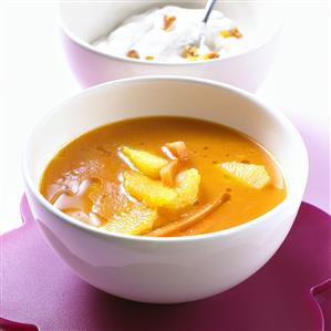 Carrot soup with pieces of orange and cream