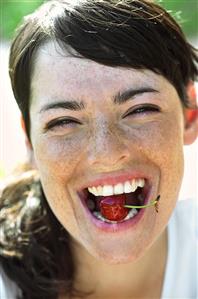 Portrait of a young woman with a cherry in her mouth