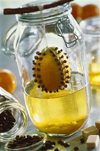 Lemon studded with cloves hanging over a sugar solution