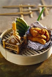 Mini-bananas coated in grated coconut and deep-fried; sauce