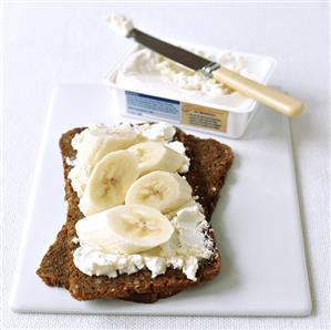 Wholemeal bread topped with soft cheese and banana slices