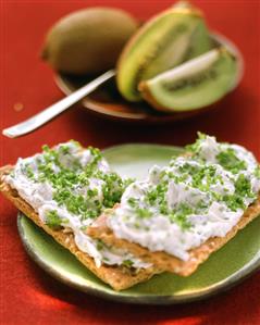 Crispbread with herb quark, kiwi fruits in background