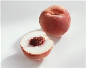 Peach (Prunus persica), variety ?Snow King?, whole and halved