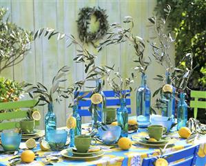 Laid table with blue bottles and olive branches