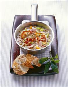 Lentil soup with bacon and sausage in small pan