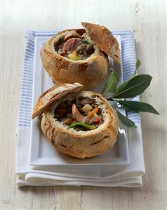 Lentil soup with bacon & sausage served in small loaves of bread