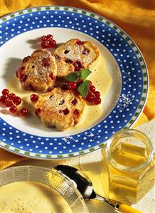 Redcurrant buns with cinnamon sauce and icing sugar