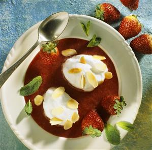 Poached meringues with flaked almonds, mint on strawberry sauce