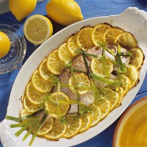 Fried sea bream with lemon slices and strips of leek