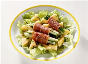 Serrano and cucumber rolls on diced melon and iceberg lettuce