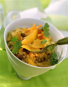 Orange rice with raisins and parsley in white bowl