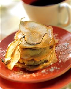 Pear pancakes with maple syrup on red plate