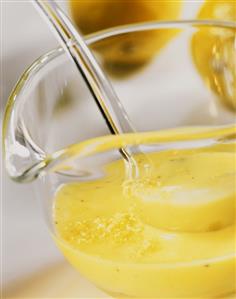 Lemon dressing in glass bowl with ladle