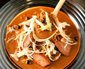 Hungarian cabbage soup with sausage on plate & spoon