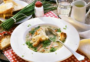 Bread soup with chives & smoked pork rib on white plate