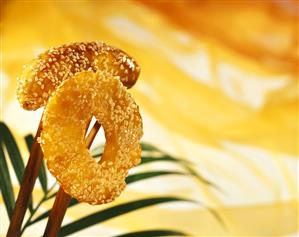 Glazed fruit (pineapple, banana) with sesame on chopsticks