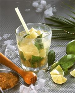 Caipirinha with lime wedges and ice cubes