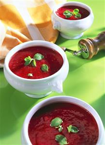 Beetroot soup with basil leaves in soup cups