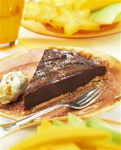 A piece of chocolate tart with ice cream on plate