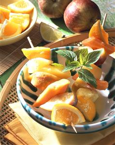 Fruit kebabs with ginger butter in a bowl