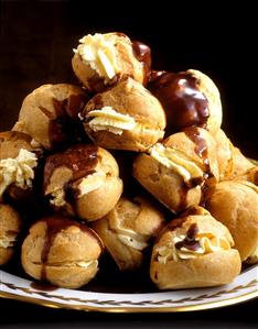 Profiteroles with cream & chocolate sauce on plate