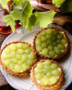 Three grape tartlets with vanilla cream on a plate