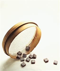 Cassis cubes with sugar and a sieve