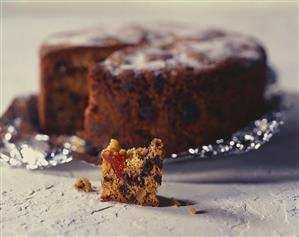 Fruit cake on foil and a small piece of cake in front