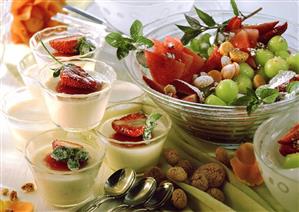 Panna cotta in small bowls, fruit salad and amaretti