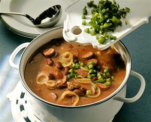 Tomato and bean soup with salami, onions and green pepper