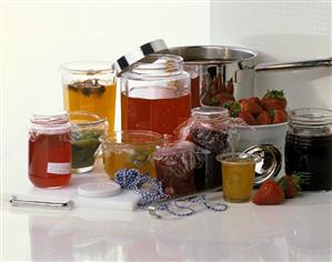 Various jam jars, jam in the pan, strawberries