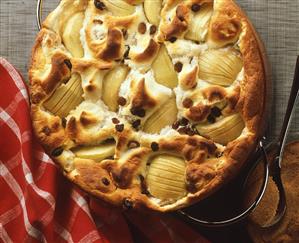 Freshly baked apple and raisin pudding in baking dish