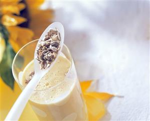 Mango ayran with sunflower seeds in glass and on spoon (1)