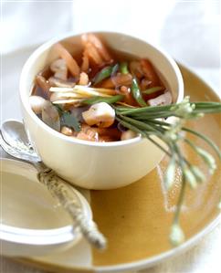 Asian vegetable soup with chives in small bowl; Spoon