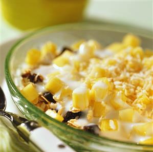 Mango muesli with grated coconut in glass bowl