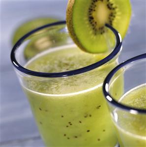 Kiwi sour in a glass with a kiwi slice on the edge