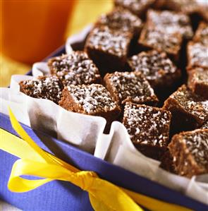 Coconut and chocolate squares in a box with a bow