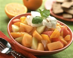 Fruit salad with cream in a red bowl