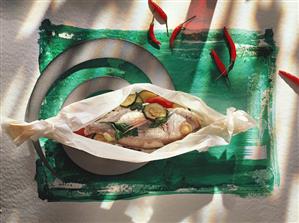 Fish with vegetables in baking paper