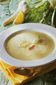 Fennel soup with salmon on white plate