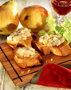 Crostini with pear and gorgonzola on chopping board