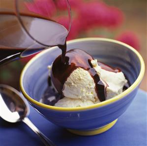 Hot chocolate sauce being poured over vanilla ice cream (1)