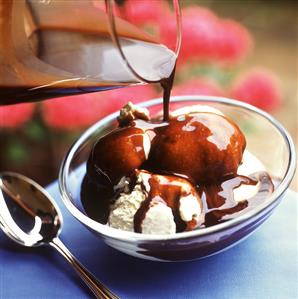 Pouring hot chocolate sauce over vanilla ice cream (2)