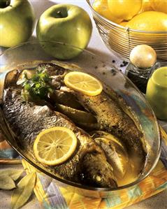 Fried trout with apples and lemon slices